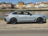 La BMW Série 6 Granola est garée sur le bord de la route, près de l'eau.