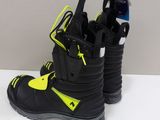pair of black and yellow snowboard boots sitting on a white surface