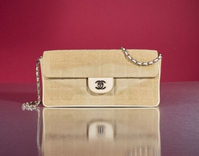 beige chanel bag on a table with a red wall in the background