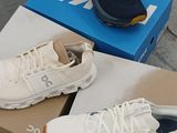 two pairs of shoes sitting on a box on the ground