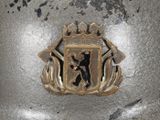 a close up of a metal object with a coat of arms on it