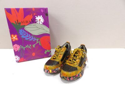 pair of yellow and black shoes sitting on a table next to a purple box