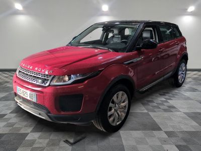 Le Range Rover rouge est garé dans le garage, sur un sol à damier.