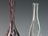 trois vases en verre posés l'un à côté de l'autre sur une table