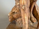 sculpture of a man and a dog on a wooden base