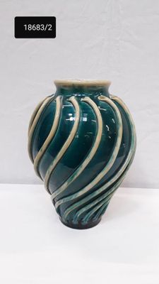 un vase bleu et blanc posé sur une surface blanche