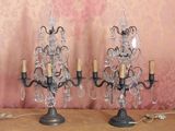 two crystal candelabs on a table with a pink background