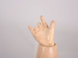 a wooden sculpture of a hand that is on a table