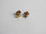 a pair of gold earrings with red stones on them
