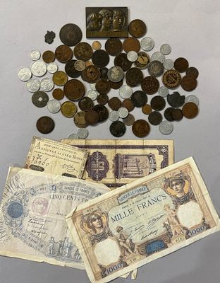 un tas de vieilles pièces et un billet de banque posés sur une table