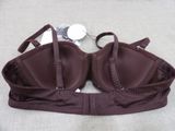 brown bralette on a bed with a pair of sunglasses on it