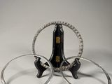 pair of silver hoop earrings and a bottle of wine on a white surface
