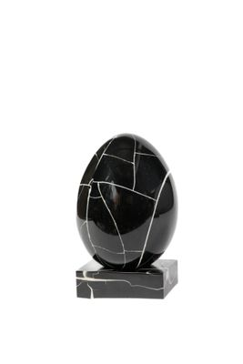 une boule en marbre noir et blanc posée sur un socle en marbre