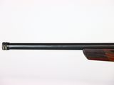a close up of a rifle with a wooden barrel on a white background