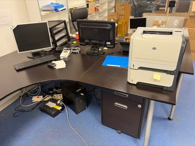 a desk with two computers and a printer on it