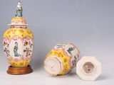 two vases and a lid with a figure on top of them