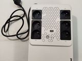 a white table with a keyboard and a power strip on it