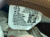 a person holding a pair of shoes with a label on it