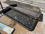 une grille métallique posée par terre à côté d'un bac en plastique