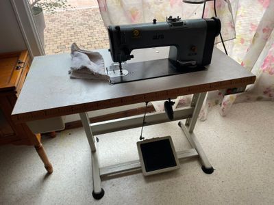 une machine à coudre posée sur une table devant une fenêtre