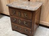 a small wooden chest of drawers with a marble top