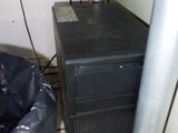 a black computer tower sitting next to a trash can