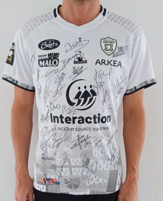 Cet homme porte une chemise blanche avec des inscriptions noires dessus.