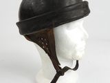 un vieux casque posé sur la tête d'un mannequin, sur une surface blanche