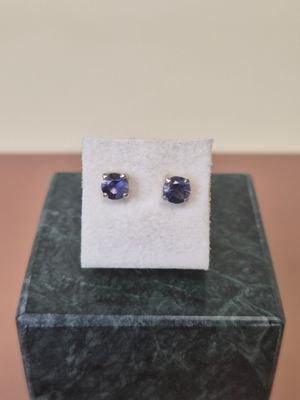 a pair of blue sapphire earrings sitting on top of a marble block