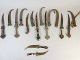 a lot of old knives and a pair of scissors on the table