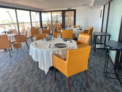 des tables et des chaises disposées dans un restaurant avec vue sur l'océan