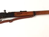 un vieux fusil avec un canon en bois et une bretelle en bois