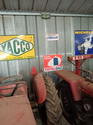 many signs on the wall of a building with a tractor