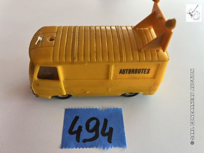 un petit bus jaune avec un homme assis dessus