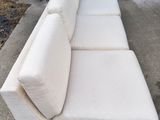 a white couch that is sitting on a concrete slab