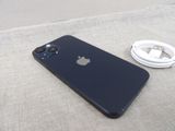 a black iphone sitting next to a charger on a table