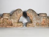 une paire de sculptures en pierre représentant un lion et un cheval, posées sur un socle blanc