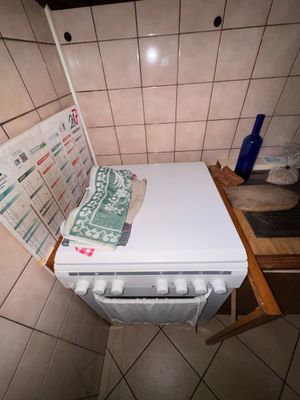 un lave-vaisselle blanc posé sur un plan de travail dans une salle de bains