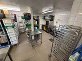 une vue d'une cuisine dont les étagères sont bien remplies de provisions