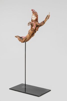 a sculpture of a person jumping in the air on a black stand