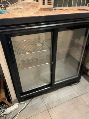 an image of a glass door refrigerator in a kitchen