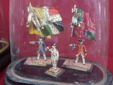 several figurines are under a glass dome on a red surface