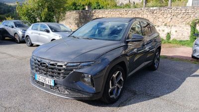 un SUV noir garé sur un parking, à côté d'un mur de pierre