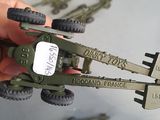 a person holding a toy army vehicle in their hand