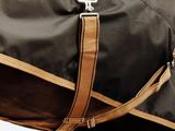 a brown and black duffel bag on a white background