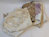 a pile of cloth on the floor next to a pair of scissors