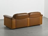 an image of a brown leather couch sitting on top of a cement floor