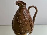 a brown vase sitting on a glass table with a white wall in the background