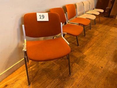 many chairs lined up in a row with a price tag on the back of them