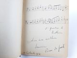 an open book with a handwritten page of music notes on it